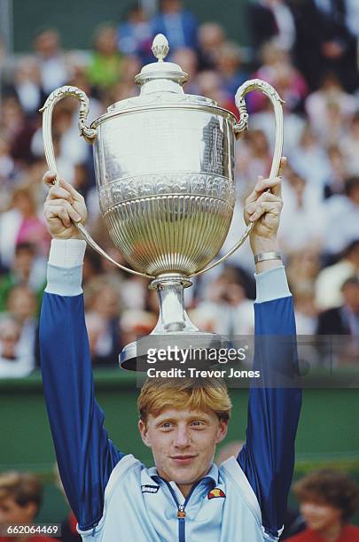 Boris Becker of Germany holds the trophy aloft after winning the Stella Artois Tennis Championship against Johan Kriek on 17 June 1985 at the Queen's...