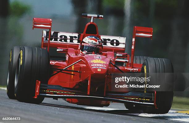 Michael Schumacher of Germany drives the Scuderia Ferrari Marlboro Ferrari F300 V10 with the aerodynamic downforce X-Wing device during practice for...