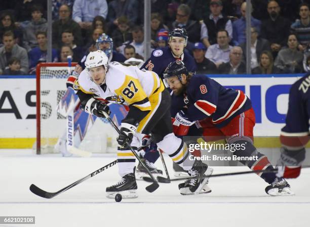 Sidney Crosby of the Pittsburgh Penguins carries the puck past Kevin Klein of the New York Rangers during the second period at Madison Square Garden...