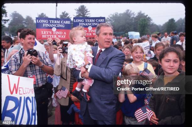 George W. Bush holds a baby June 14, 1999 in New Castle, NH. Texas Governor Bush begins his New Hampshire presidential primary campaign on this day.
