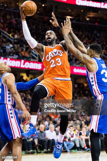 LeBron James of the Cleveland Cavaliers shoots between Gerald Henderson and Shawn Long of the Philadelphia 76ers during the second half at Quicken...