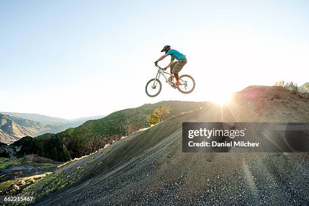 guy jumping a big jump on a mountain bike. - extreme sports bike stock pictures, royalty-free photos & images