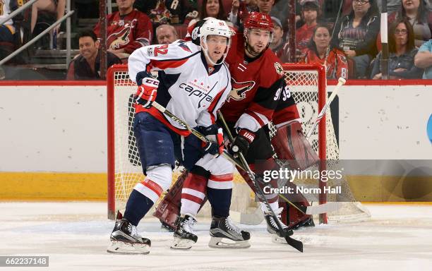 Evgeny Kuznetsov of the Washington Capitals and Alexander Burmistrov of the Arizona Coyotes battle for position in front of the net during the first...
