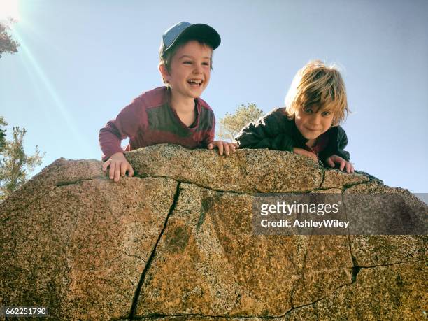 jungen wandern und spielen in den bergen - kinder klettern stock-fotos und bilder