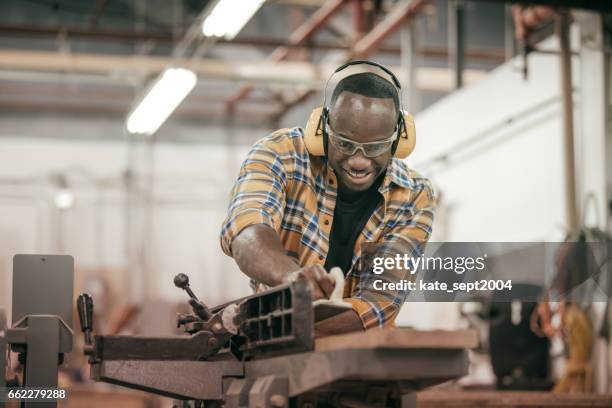 male carpenter working with power tools in his wood shop - carpenter stock pictures, royalty-free photos & images