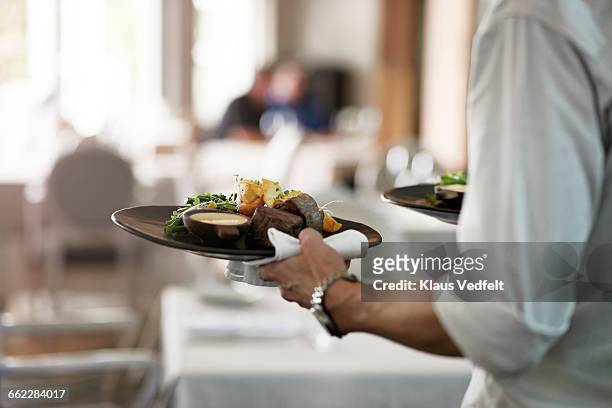 close-up of waiter walkiing with dishes - dining restaurant ストックフォトと画像