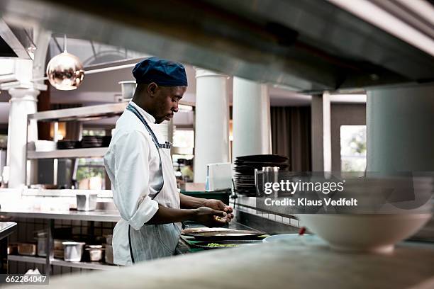 chef sorting out peas in open kitchen - food plating stock-fotos und bilder