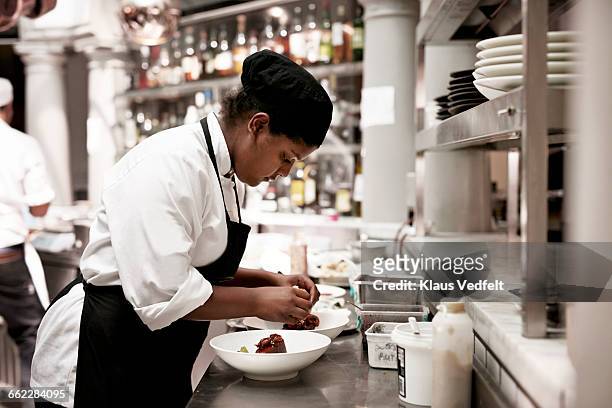 chef fisinshing dishes in the kitchen - chef apron stock pictures, royalty-free photos & images
