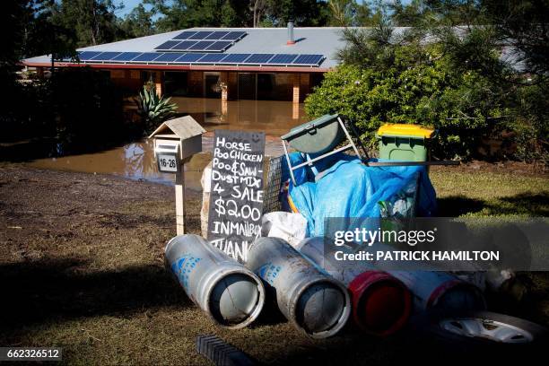 Debris lies abandoned in front of a home, partially submerged under floodwaters caused by Cyclone Debbie, in North MacLean, Brisbane on April 1,...