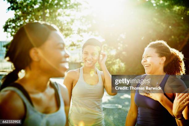 friends laughing together after morning run - happy woman in early morning sunlight photos et images de collection