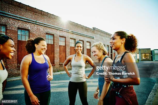 laughing group of women resting after run - after run photos et images de collection