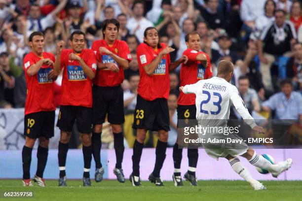 Real Madrid's David Beckham curls a free kick around the Mallorca defensive wall