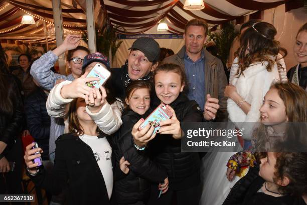 Presenter Jean Luc Reichmann pose for a selfie with kids during Foire du Trone Auction Launch Party to benefit 'Les Petits Princes' Children Care...