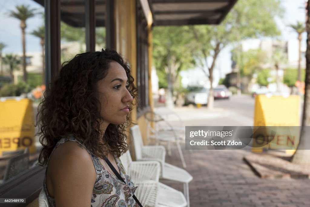 Side view of woman sitting outside neighborhood cafe