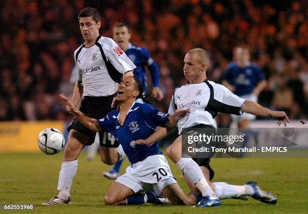 Everton's Steven Pienaar goes to ground under the challenge from Luton Town's Jaroslaw Fojut .