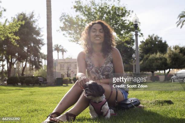 woman sitting in park with dog - scott zdon stock-fotos und bilder
