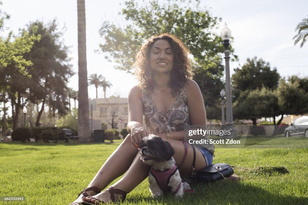 Woman sitting in park with dog