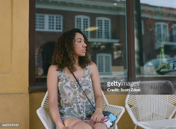 woman sitting outside cafe - scott zdon foto e immagini stock