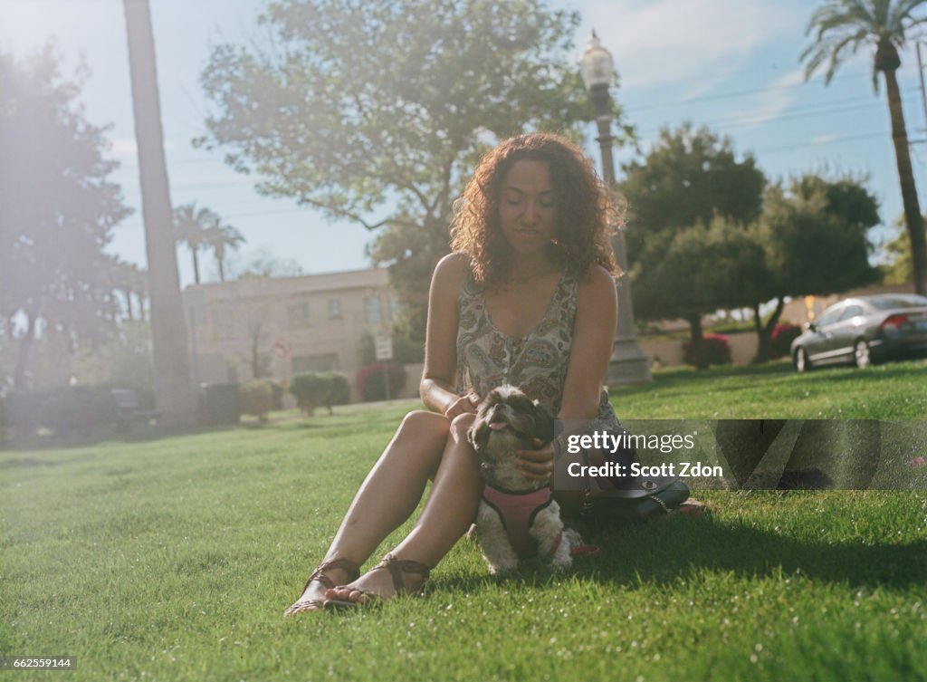 Woman sitting in park with dog