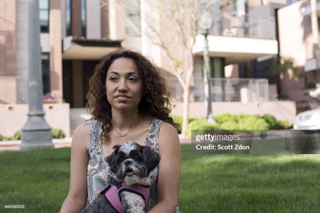 Woman sitting in park with dog on her lap