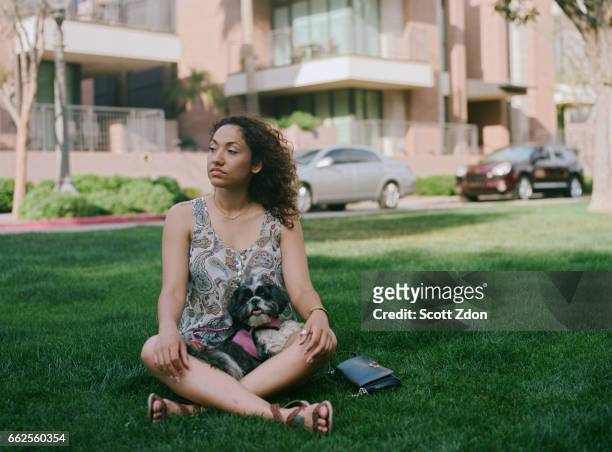 woman sitting in park with dog - scott zdon foto e immagini stock