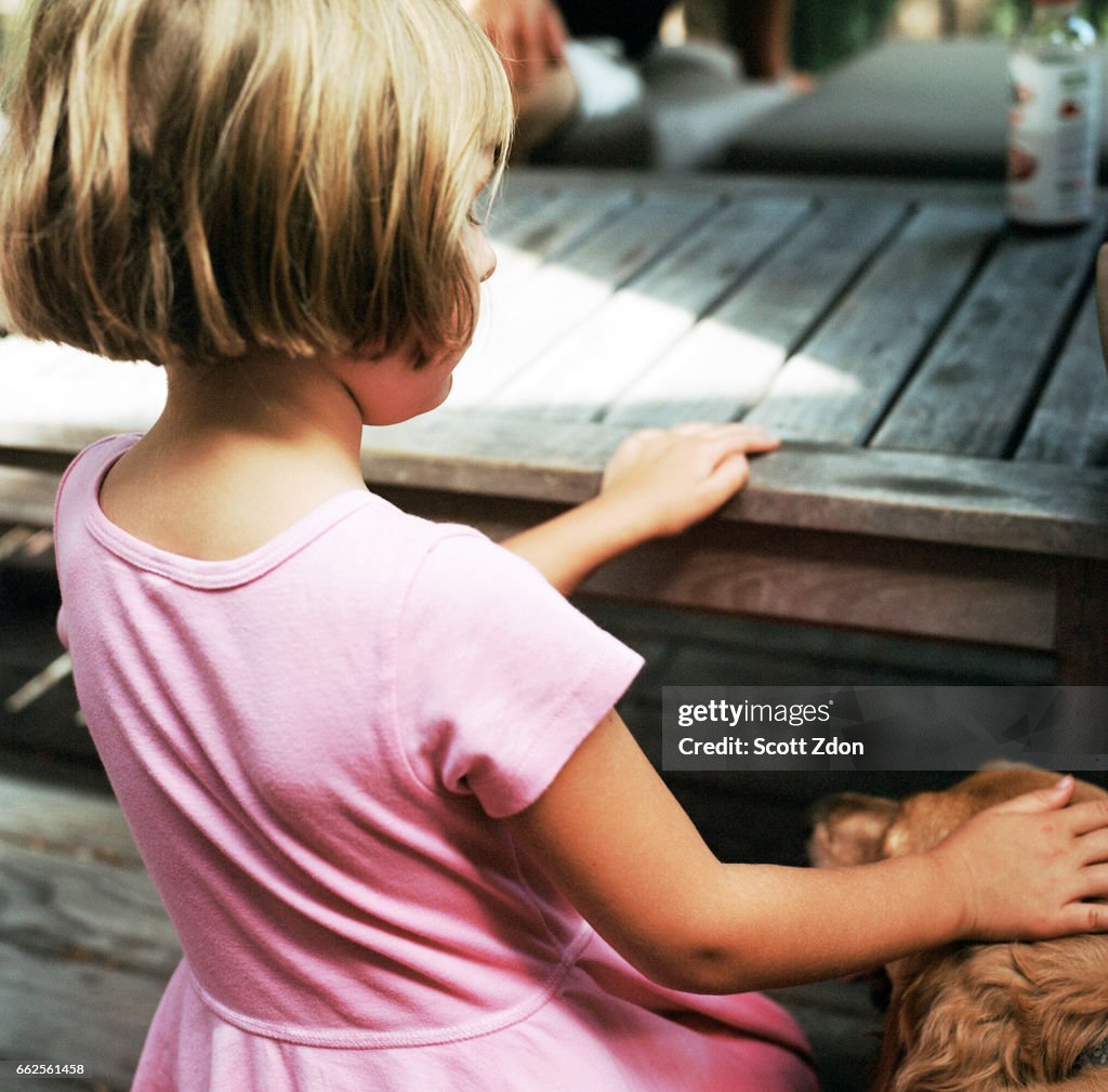 Girl petting golden retriever