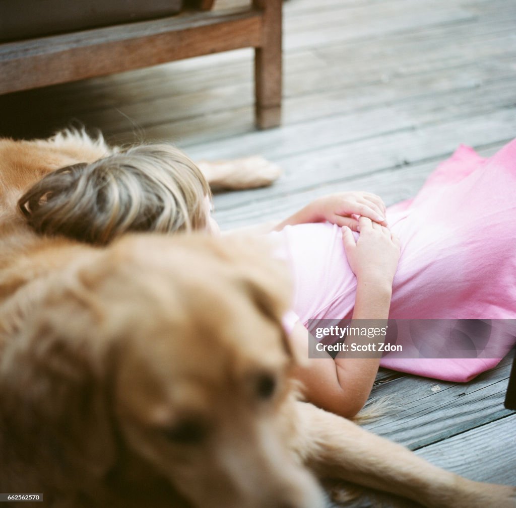 Girl resting on golden retriever