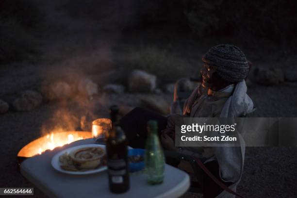 woman relaxing by a camp fire - scott zdon stock-fotos und bilder