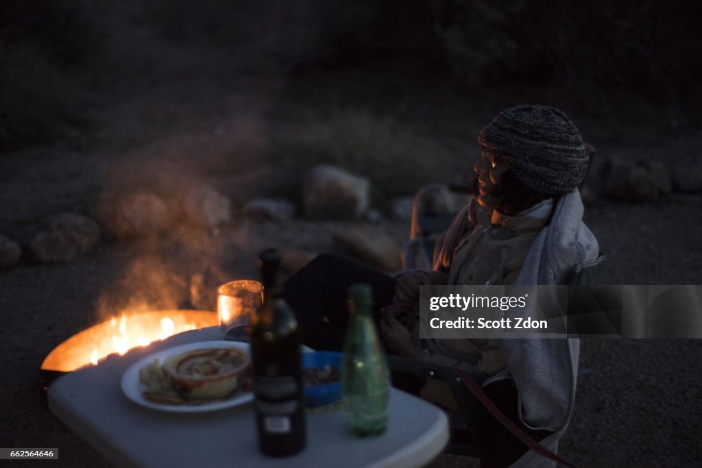 Woman relaxing by a camp fire