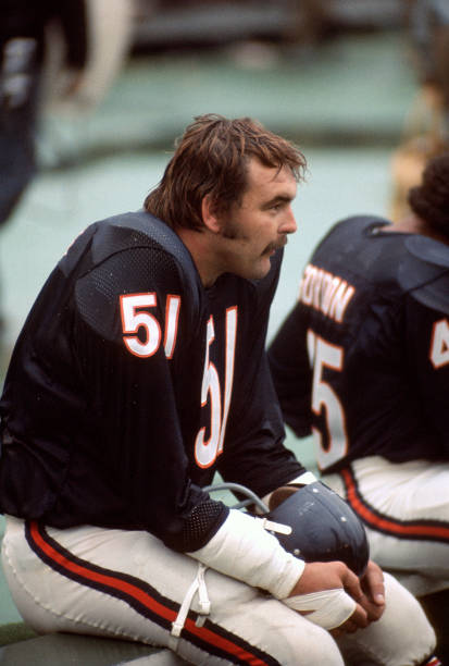 Dick Butkus of the Chicago Bears looks on from the bench during an NFL football game circa 1971 at Soldier Field in Chicago, Illinois. Butkus played...