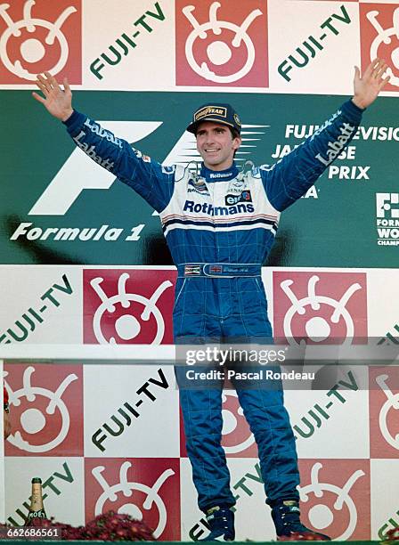 Damon Hill of Great Britain and driver of the Rothmans Williams Renault Williams FW18 Renault RS8 V10 celebrates winning the race and the World...