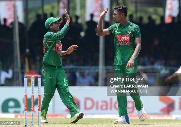 Bangladesh cricketer Mustafizur Rahman celebrates with teammate Mehedi Hasan after he dismissed Sri Lankan batsman Kusal Mendis during the third and...