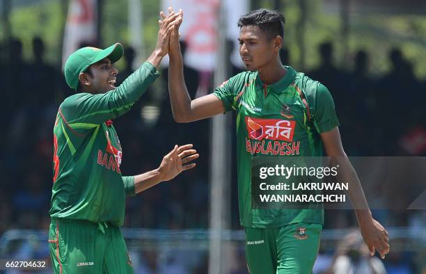 Bangladesh cricketer Mustafizur Rahman celebrates with teammate Mehedi Hasan after he dismissed Sri Lankan batsman Kusal Mendis during the third and...