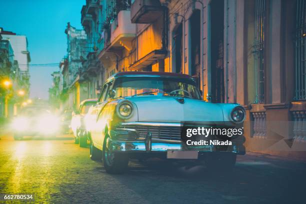 old american car on street at dusk, havana, cuba - cuba night stock pictures, royalty-free photos & images