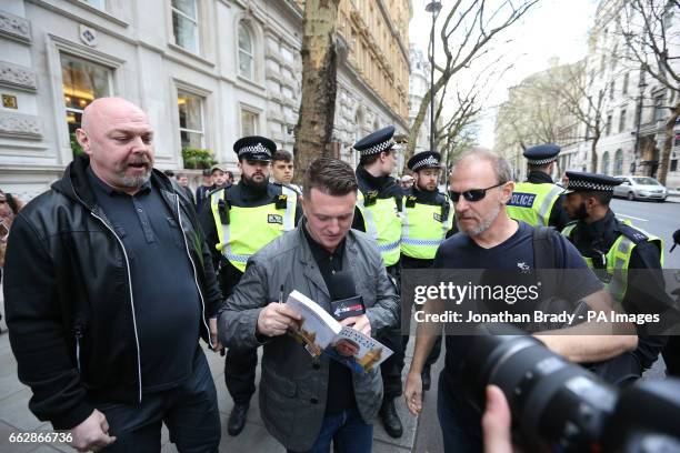 Former spokesman and leader of the English Defence League Tommy Robinson signs a copy of his book in London, during a counterprotest by UAF against...