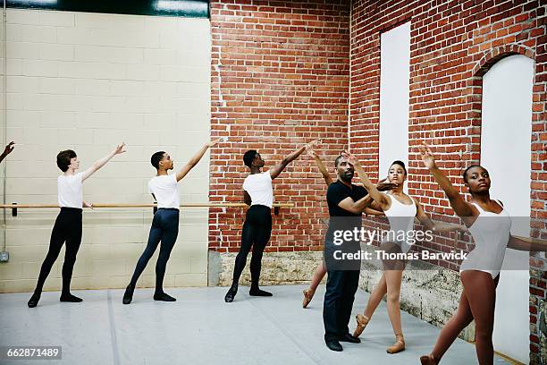 ballet instructor adjusting students form - dance teacher foto e immagini stock