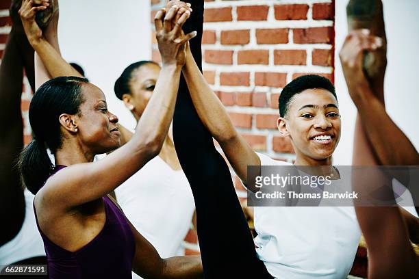 smiling dance instructor adjusting students form - ballet boy stock pictures, royalty-free photos & images