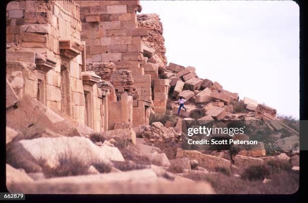 Man climbs through rubble in the ancient city September 12, 1999 in Leptis Magna, Libya. Originally established by the Phoenicians in the sixth...