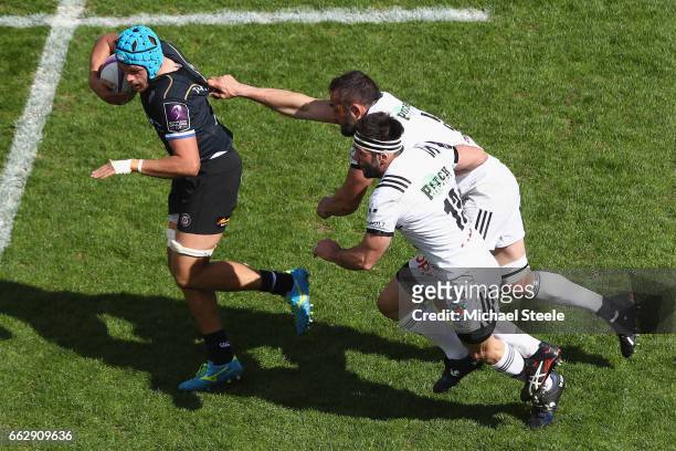 Zach Mercer of Bath breaks clear of Arnaud Mignardi and Arnaud Mela of Brive during the European Rugby Challenge Cup Quarter Final match between Bath...