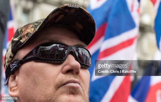 British Union Jack flags are refelcted in the sunglasses of a protester during a protest titled 'London march against terrorism' in response to the...