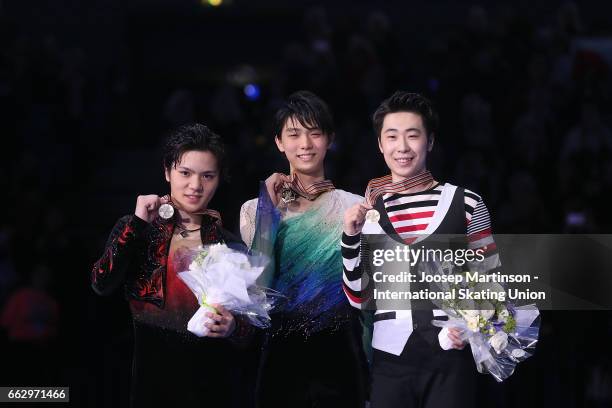 Shoma Uno and Yuzuru Hanyu of Japan and Boyang Jin of China pose in the Men's medal ceremony during day four of the World Figure Skating...