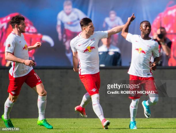 Leipzig's Guinean midfielder Naby Keita is congratulated by his teammates Scottish midfielder Oliver Burke and Austrian forward Marcel Sabitzer after...