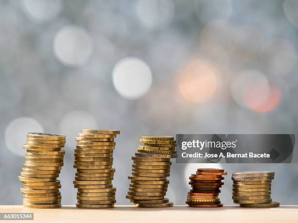 euro and cent coins arranged in heaps of different sizes - montón stock pictures, royalty-free photos & images