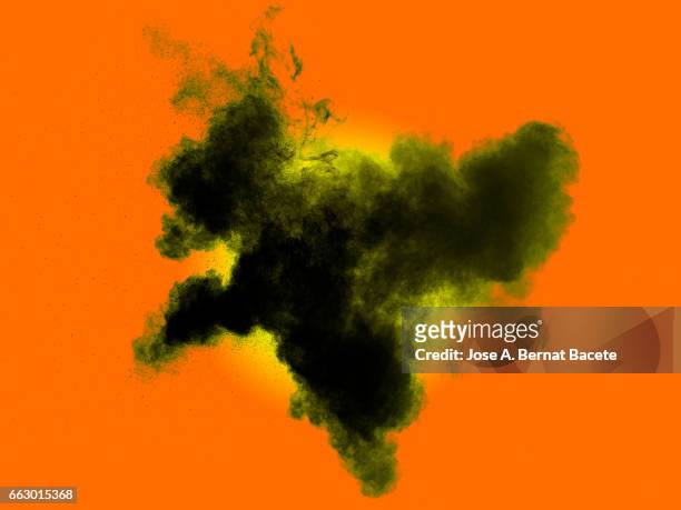 explosion of a cloud of powder of particles of  gray and black on a orange background - etéreo stockfoto's en -beelden