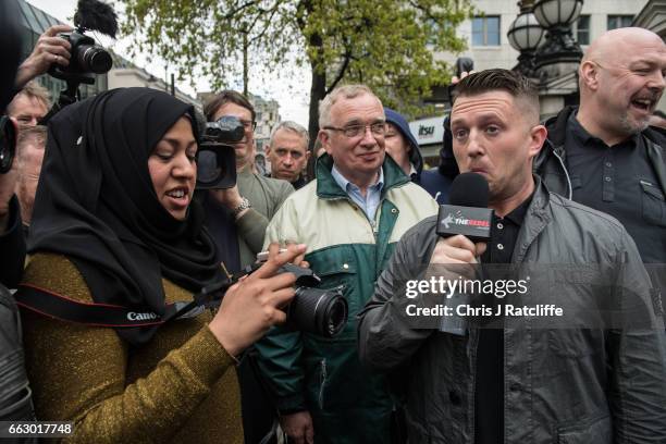 Former English Defence League leader Tommy Robinson reacts as he speaks to a muslim woman during a protest titled 'London march against terrorism' in...