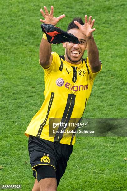 Pierre-Emerick Aubameyang of Dortmund catches his mask after scoring his teams first goal during the Bundesliga match between FC Schalke 04 and...