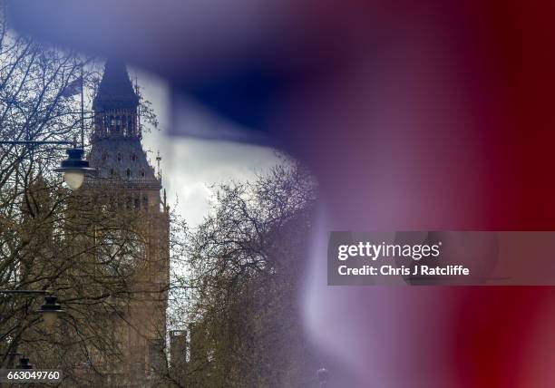 Protesters chant and wave British Union Jack flags as the Houses of Parliament are seen in the background during a protest titled 'London march...