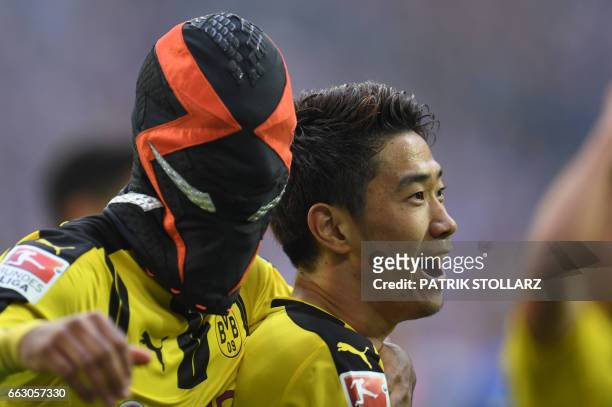 Dortmund's Gabonese striker Pierre-Emerick Aubameyang wears a mask as he celebrates with his teammate Dortmund's Japanese midfielder Shinji Kagawa...