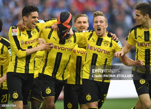 Dortmund's Gabonese striker Pierre-Emerick Aubameyang wears a mask as he celebrates with his teammates Dortmund's after scoring the 0-1 during the...