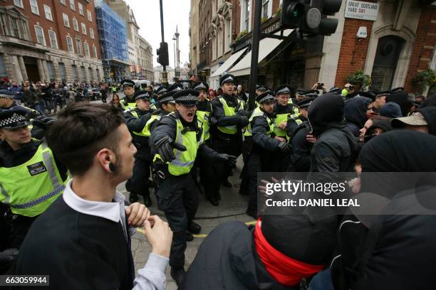 Anti-facist activists clash with police as they counter protest against marches by the far-right English Defence League and Britain First in central...